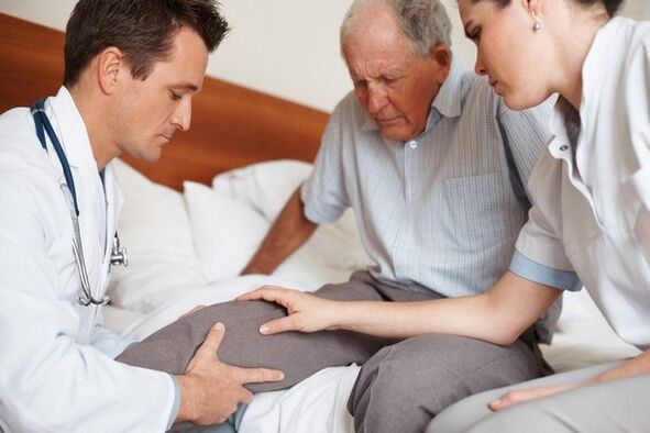 Arts die de knie van de patiënt onderzoekt